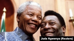 FILE- President Nelson Mandela and Brazilian soccer legend Pele smile for photographers at Union Buildings in Pretoria, South Africa, March 1995.
