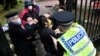 FILE - A Hong Kong protester, center, and Chinese Consulate staff scuffle as police try to intervene, in Manchester, England, Oct. 16, 2022.