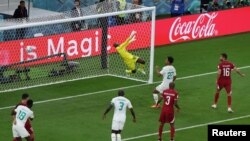 Senegal's Famara Diedhiou scores the second goal past Qatar's Meeshal Barsham in a Group A fixture at the 2022 FIFA World Cup