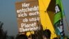 FILE - Protesters hold a poster reading "This is also about the decision if our planet will survive" as they attend a demonstration at the Garzweiler lignite open cast mine near Luetzerath, western Germany, on Nov. 12, 2022. 