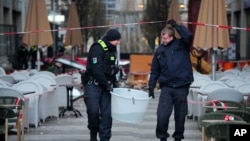 FILE - Police officers carry a plastic tub with rescued fish after a huge aquarium bursts in Berlin, Germany, Dec. 16, 2022.