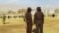 Taliban security personnel stand guard ahead of the public flogging of women and men at a football stadium in Charikar city of Parwan province, Dec. 8, 2022.
