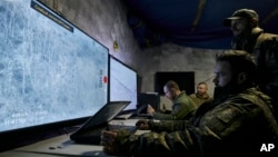 Ukrainian soldiers watch drone feeds from an underground command center in Bakhmut, Donetsk region, Ukraine, Dec. 25, 2022. 