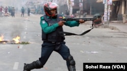 A policeman fires his gun at opposition BNP activists in Dhaka, Bangladesh, Dec 7, 2022. One BNP activist was killed and over 60 activists were injured as a result of police using force. 
