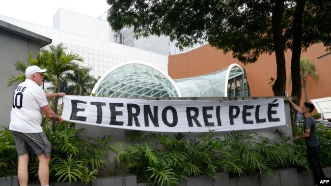 Fans of Brazilian football legend Pele hang a banner reading "Eternal King Pele," in Sao Paulo, Brazil, Dec. 29, 2022.