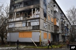 People try to extinguish a fire after a Russian attack in Bakhmut, in the Donetsk region, Ukraine, Dec. 16, 2022.