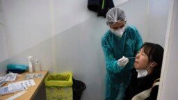 FILE - A passenger arriving from China is tested for COVID-19 at the Roissy Charles de Gaulle airport, north of Paris, Jan. 1, 2023. 