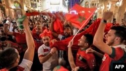 Supporters of the Morocco national football team celebrate in Doha on December 1, 2022, after Morocco qualified to the round of 16 of the Qatar 2022 FIFA World Cup. 