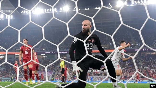 Switzerland's Remo Freuler, right, celebrates scoring his team's third goal past Serbia's goalkeeper Vanja Milinkovic-Savic during a World Cup match at Stadium 974 in Doha on Dec. 2, 2022.