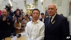 FILE - Hong Kong protester Bob Chan, left, who alleged he was dragged into the Chinese Consulate in Manchester and beaten during a demonstration, is pictured with British MP Iain Duncan Smith during a news conference in London, Oct. 19, 2022.