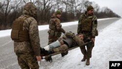 Médicos del ejército ucraniano evacuan a un soldado herido en una carretera no muy lejos de Soledar, región de Donetsk, el 14 de enero de 2023.