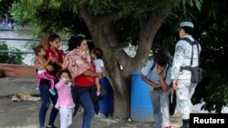 Dos familias venezolanas son deportadas a Guatemala mientras agentes del Instituto Nacional de Migración y miembros de la Guardia Nacional laboran en un operativo de seguridad en Ciudad Hidalgo, en el estado de Chiapas, México, el 22 de octubre de 2022.