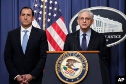 Attorney General Merrick Garland speaks during a news conference at the Department of Justice, Thursday, Jan. 12, 2023, in Washington, as John Lausch, the U.S. Attorney in Chicago, looks on.