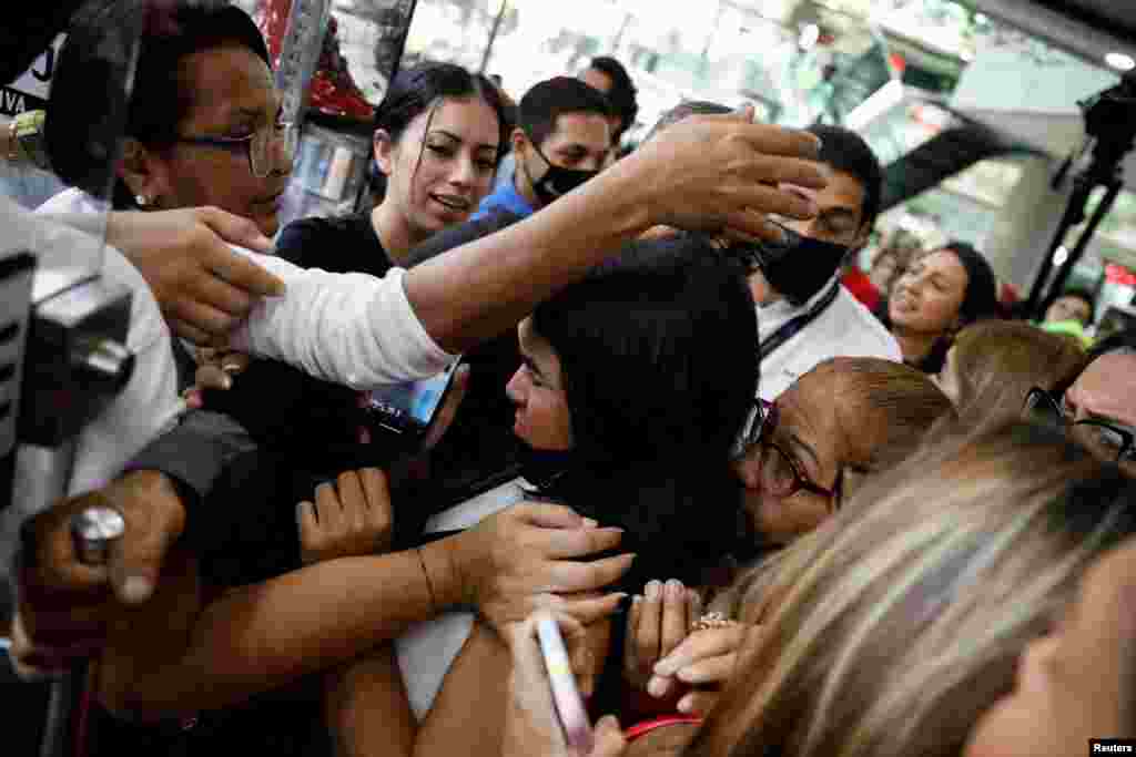 Consumers struggle to enter a store to buy shoes in a store at a shopping center during Black Friday sales, in Caracas, Venezuela.