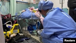 上海一家医院急诊室的一名医生正在给一名躺在地上的新冠病人进行心肺复苏。（2023年1月5日）