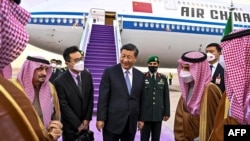 This handout picture released by the Saudi Press Agency SPA shows China's President Xi Jinping being received by Saudi Arabia's Foreign Minister Prince Faisal bin Farhan and the Governor of Riyadh province at King Khalid International Airport in Riyadh, Dec. 7, 2022.