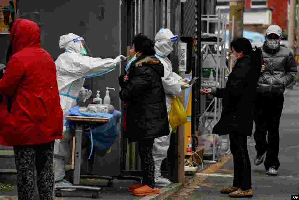 Residents undergo swab testing at a residential area under lockdown due to COVID-19 coronavirus restrictions in Beijing.