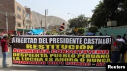 Partidarios del expresidente de Perú, Pedro Castillo, sostienen una pancarta que dice "Libertad para el presidente Castillo, Restitución, Asamblea Constituyente" mientras se reúnen frente a la prisión policial donde está detenido Castillo, en Lima, el 15 de diciembre de 2022.