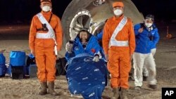 Tiga astronaut China telah kembali ke Bumi dengan selamat hari Minggu (4/12), seorang astronaut di antaranya, Chen Dong melambai saat duduk di luar kapsul misi luar angkasa berawak "Shenzhou-14". 