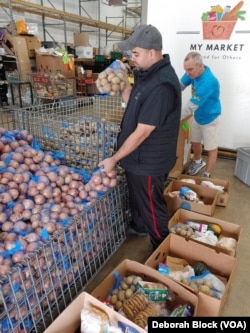 Leo Delgado, warehouse manager at Food for Others in Fairfax, Virginia helps with packing food boxes for Thanksgiving, Nov. 16, 2022.