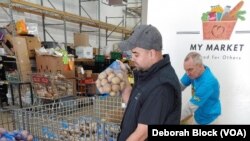 Leo Delgado, gerente de almacén de Food for Others en Fairfax, Virginia, ayuda a empacar cajas de alimentos para el Día de Acción de Gracias. 16 de noviembre de 2022 (Deborah Block/VOA)
