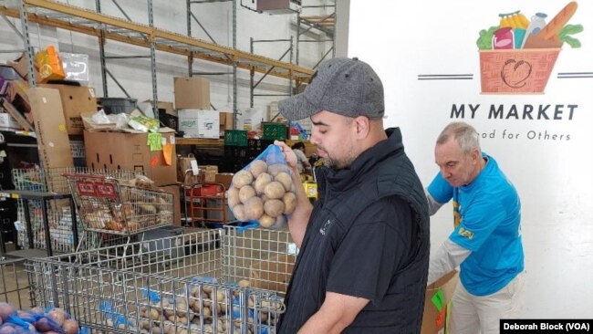 Leo Delgado, gerente de almacén de Food for Others en Fairfax, Virginia, ayuda a empacar cajas de alimentos para el Día de Acción de Gracias. 16 de noviembre de 2022 (Deborah Block/VOA)