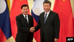 2020年1月6日中国国家主席习近平(右)在北京人民大会堂会见老挝总理通伦·西苏里(左)