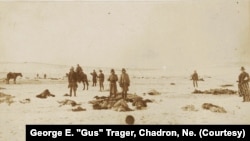 This photograph by Chadron, Nebraska, photographer George E. "Gus" Trager photographer shows soldiers holding moccasins and other items they have looted from the dead at the Wounded Knee Massacre site.