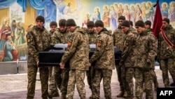 Ukrainian soldiers carry the coffin of Denys Galushko, a Ukrainian serviceman killed while fighting against Russian troops in Bakhmut, during his funeral at the Orthodox Saint Michael's Golden-Domed Monastery in Kyiv on Jan. 12, 2023.