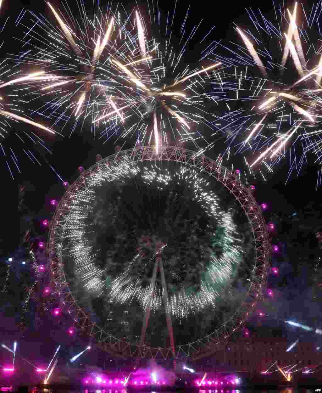 Los fuegos artificiales estallan alrededor del London Eye durante las celebraciones de Año Nuevo en el centro de Londres poco después de la medianoche del 1 de enero de 2023. [AFP]