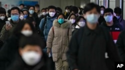 People walk between one subway station and another during the morning rush hour in Beijing on Dec. 20, 2022.