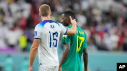 England's Eric Dier comforts Senegal's Pape Matar Sarr at the end of the World Cup round of 16 soccer match between England and Senegal, at the Al Bayt Stadium in Al Khor, Qatar, Sunday, Dec. 4, 2022.