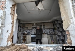 Liubov Onyschenko looks around her house, which was heavily damaged by a Russian missile strike, amid Russia's attack on Ukraine, in the village of Kupriianivka, Zaporizhzhia region, Ukraine, Dec. 7, 2022.