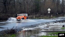 A vehicle drives on a flooded road in Sebastopol, California, Jan. 5, 2023. 