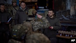 FILE - In this photo provided by the Ukrainian Presidential Press Office, Ukrainian President Volodymyr Zelenskyy, right, awards a serviceman at the site of the heaviest battles with the Russian invaders in Bakhmut, Ukraine, Tuesday, Dec. 20, 2022. 