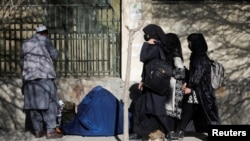 Sejumlah pelajar perempuan berjalan dekat Universitas Kabul di Kabul, Afghanistan, 21 Desember 2023. (Foto: Ali Khara/Reuters)