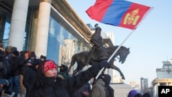 蒙古國示威者在首都烏蘭巴托國家宮前揮舞國旗抗議與中國相關的一起煤炭交易腐敗醜聞。 （2022年12月5日）