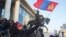 蒙古国示威者在首都乌兰巴托国家宫前挥舞国旗抗议与中国相关的一起煤炭交易腐败丑闻。（2022年12月5日）