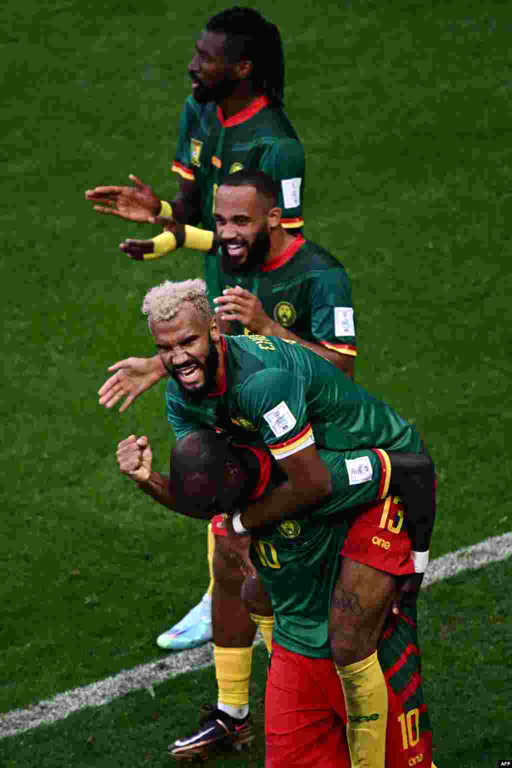 Attaquanr ya Cameroun #13 Eric Maxim Choupo-Moting (C) azali kosepela na baninga ba ye ba ekipi na ye nsima na kotia mongete na match ya groupe G ya Mondila Qatar 2022 na stade al-Janoub, Doha, 28 novembre 2022. (Photo Anne-Christine POUJOULAT / AFP)