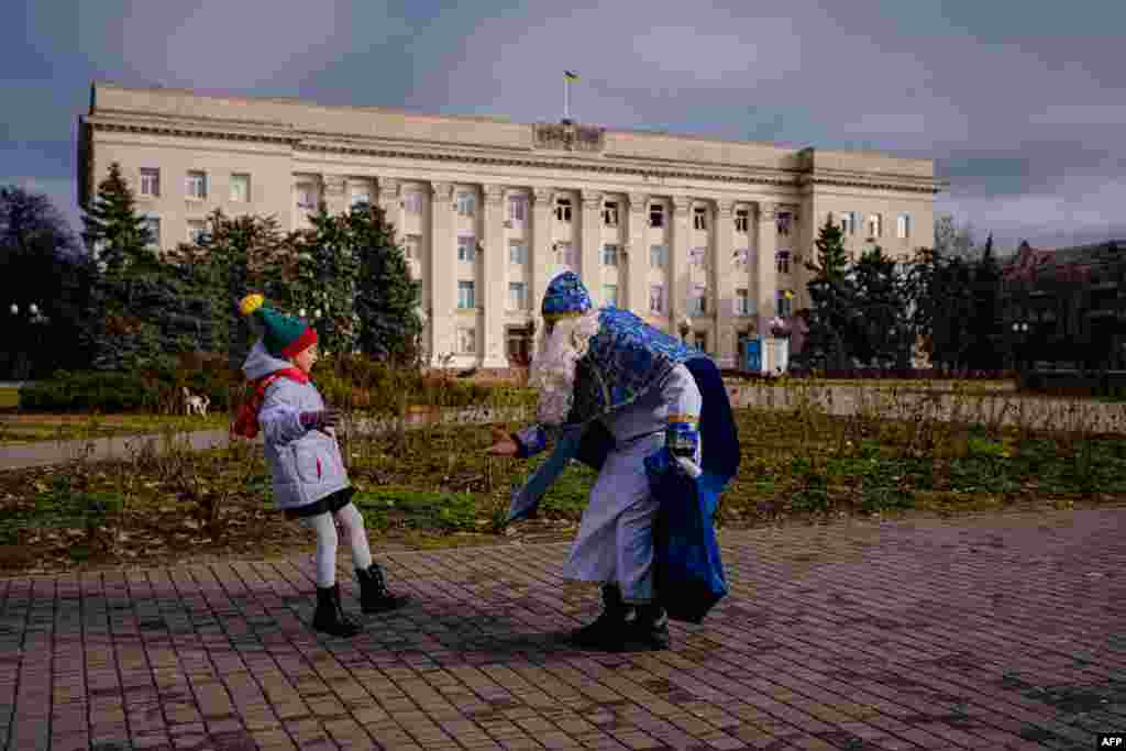 A girl meets a man dressed as Saint Mykola (Saint Nicolas) in Kherson amid the Russian invasion of Ukraine.