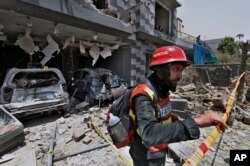 Dalam foto tanggal 23 Juni 2021 ini, seorang petugas penyelamat memeriksa lokasi ledakan di Lahore, Pakistan. Para pejabat Pakistan menuduh India mendalangi pengeboman tahun lalu itu.