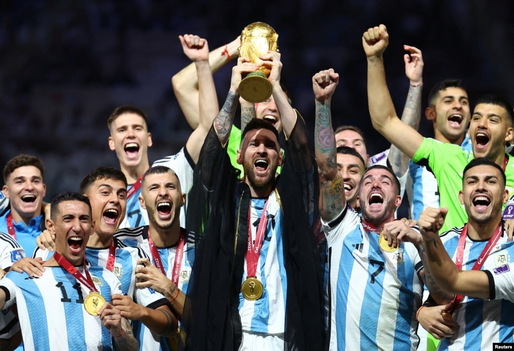 El argentino Lionel Messi levanta el trofeo de la Copa del Mundo junto a sus compañeros de equipo mientras celebran tras ganar el Mundial de Qatar 2022. 