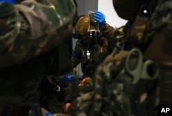 Ukrainian servicemen administer first aid to a wounded soldier in a shelter in Soledar, the site of heavy battles with Russian forces in the Donetsk region, Ukraine, Jan. 8, 2023.