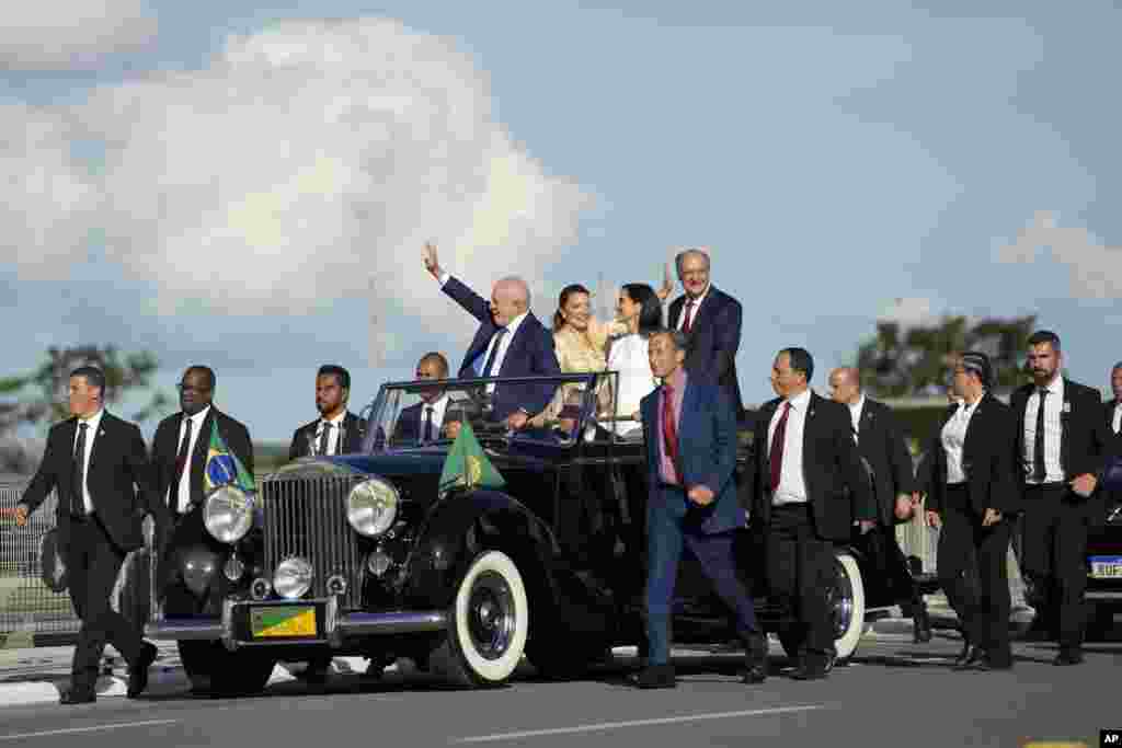 Претседателот Луис Инасио Лула да Силва, лево, неговата сопруга Росангела Силва, централно лево, потпретседателот Гералдо Алкмин, десно и неговата сопруга Марија Лусија Рибеиро ги поздравуваат симпатизерите додека се упатуваат кон палатата Планалто во Бразилија, јануари. 1, 2023 година.