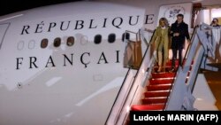 Presiden Prancis Emmanuel Macron dan istrinya Brigitte keluar dari peswat ketika tiba di pangkalan udara Andrews di Maryland pada 29 November 2022 dalam kunjungannya ke AS. (AFP/Ludovic Marin)