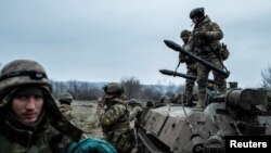 Militares del batallón Carpathian Sich se ven cerca de un vehículo blindado de transporte de personal en la línea del frente, mientras continúa el ataque de Rusia contra Ucrania, cerca de la ciudad de Lyman, región de Donetsk, Ucrania, el 8 de diciembre de 2022.
