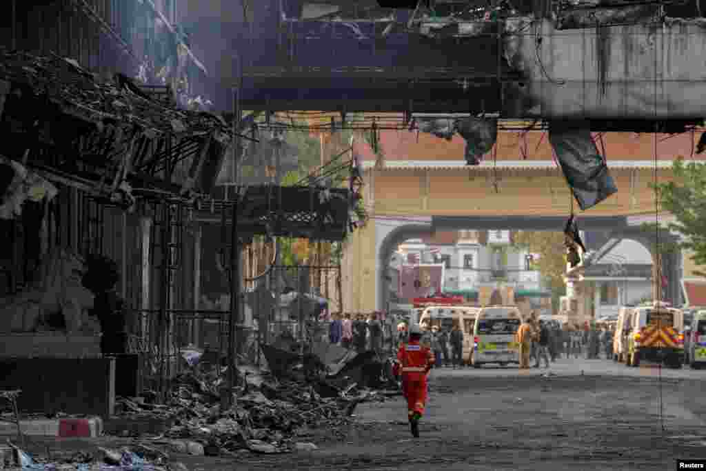 Thai and Cambodian rescuers gather in front of the Grand Diamond hotel-casino as they struggle to extricate dozens of people feared trapped after a deadly fire broke out, in Poipet near the Thailand border, Cambodia.