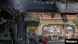 Rescuers gather in front of the Grand Diamond hotel-casino after a deadly fire broke out, in Poipet near the Thailand border, Cambodia.