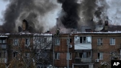 Ukrainian State Emergency Service firefighters work to extinguish a fire at the scene of a Russian shelling in the town of Vyshgorod outside of the capital Kyiv, Ukraine, Nov. 23, 2022. 