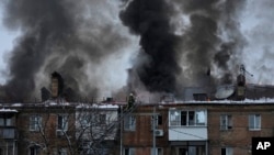 Ukrainian State Emergency Service firefighters work to extinguish a fire at the scene of a Russian shelling in the town of Vyshgorod outside of the capital Kyiv, Ukraine, Nov. 23, 2022. 